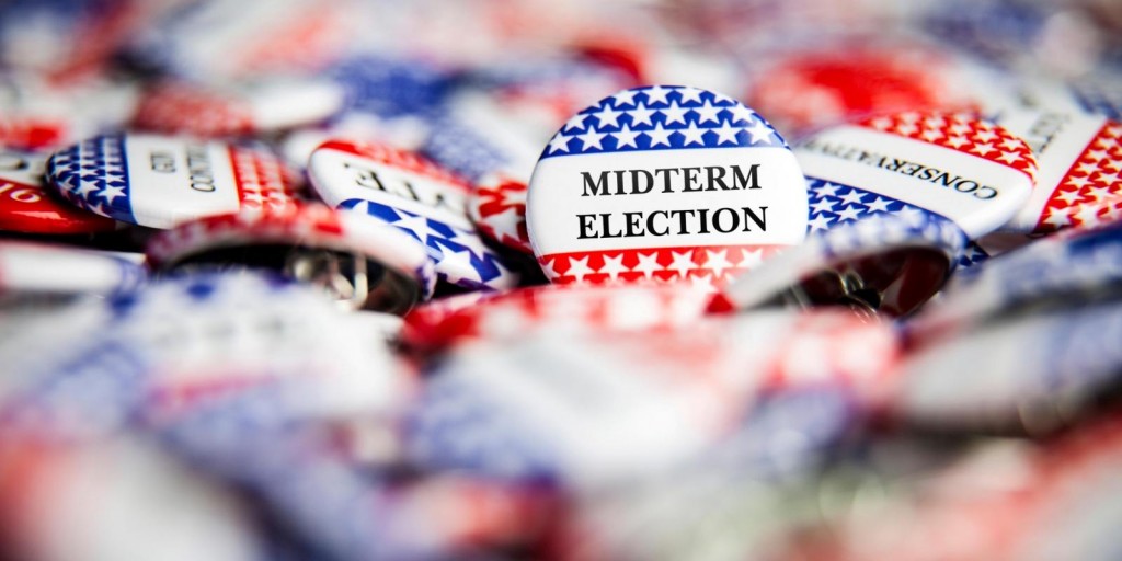 Photo of a pile of red, white and blue buttons that say 